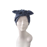 A navy blue fabric headwrap or turban hat styled on a white mannequin head and upper torso against a plain white background.