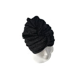 Black knit turban on a mannequin head against a white background