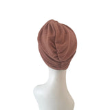 Brown turban on a mannequin head against a white background