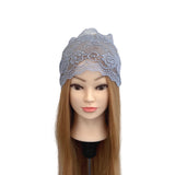 Mannequin head with long brown hair wearing a gray lace headband on a white background