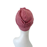 Pink headscarf on a mannequin head against a white background