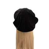 Black beret on a mannequin head with blonde hair against a white background
