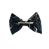 Navy blue bow tie with white leaf patterns on a white background