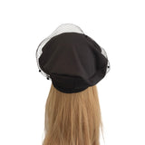 Black beret with decorative mesh on a mannequin head against a white background