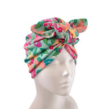 A multicolor floral fabric headwrap styled on a white mannequin head against a plain white background.