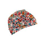 A floral twist-front headband with a vibrant pattern of orange, pink, and red flowers with green and teal leaves on a light cream background, shown on a plain white background.