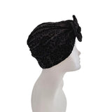Black patterned headscarf on a mannequin head against a white background