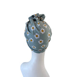 Drawstring bag with daisy pattern on a white mannequin head.