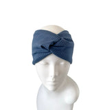 Blue knitted headband on a mannequin head against a white background