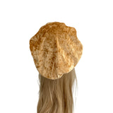 Brown beret on a mannequin head with blonde hair against a white background