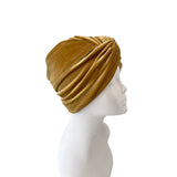 Gold turban on a mannequin head against a white background