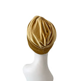 Gold turban on a mannequin head against a white background
