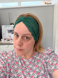 Person wearing a green headband in a sewing room