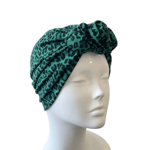 Green leopard print headband on a mannequin head against a white background