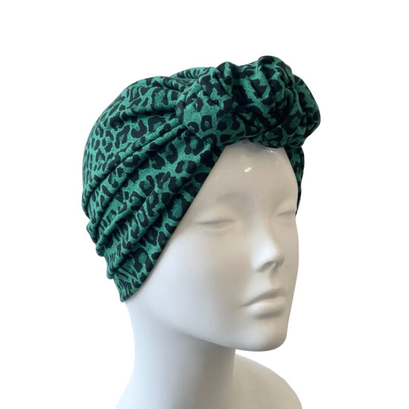 Green leopard print headband on a mannequin head against a white background