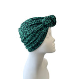 Green leopard print headband on a mannequin head against a white background