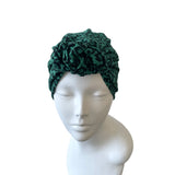Green patterned headband on a mannequin head against a white background