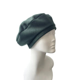 Green beret on a mannequin head against a white background