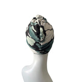 Turban with camouflage pattern on a mannequin head against a white background
