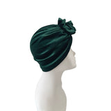 Green turban with a bow on a mannequin head against a white background