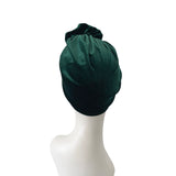 Dark green headscarf on a mannequin head against a white background