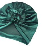 Green velvet turban with a knot on a white background