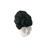 Black and green striped headscarf on a mannequin head against a white background