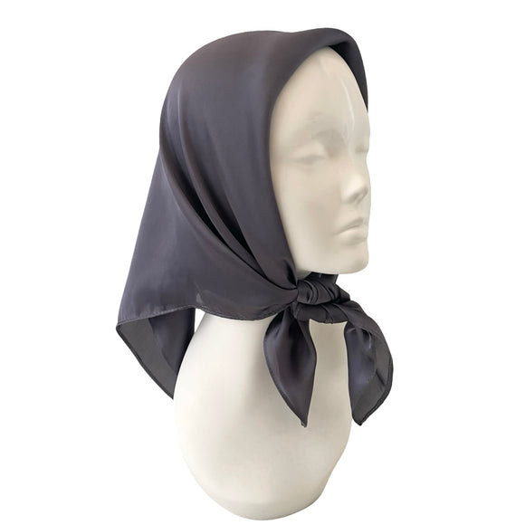 Mannequin head wearing a gray headscarf on a white background