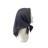 Dark gray headscarf on a mannequin head against a white background