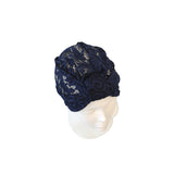 Navy blue knitted turban on a mannequin head against a white background