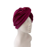 Maroon turban on a mannequin head against a white background