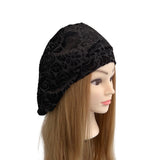 Black patterned headscarf on a mannequin head with long brown hair against a white background