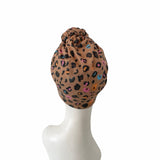 Leopard print headscarf on a mannequin head against a white background