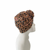 Leopard print headscarf on a mannequin head against a white background