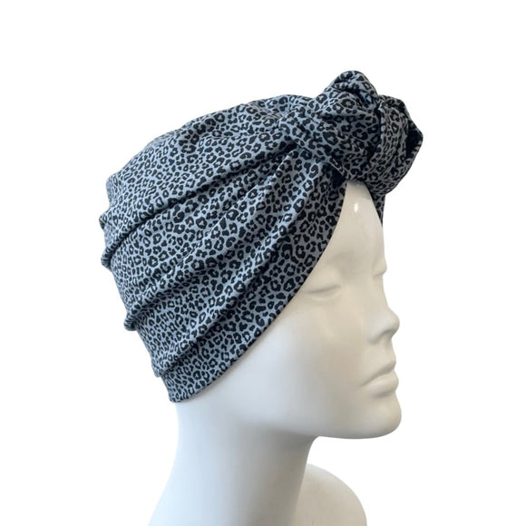 Black and blue patterned headscarf on a mannequin head against a white background