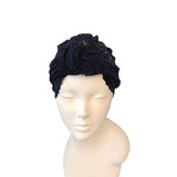 Navy blue headband with floral design on a mannequin head against a white background