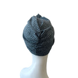 Black and white patterned headscarf on a mannequin head against a white background