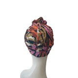 Colorful patterned headscarf on a mannequin head against a white background