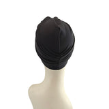 Black swim cap on a mannequin head against a white background