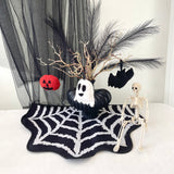 Halloween-themed decor with a skeleton, pumpkins, and decorative elements on a spiderweb mat.