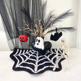Halloween-themed decor with a skeleton, pumpkins, and decorative elements on a spiderweb mat.
