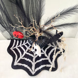 Halloween-themed decorative wreath with black tulle, branches, pumpkins, and a skeleton on a white background.