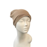 Beige beanie on a mannequin head against a white background