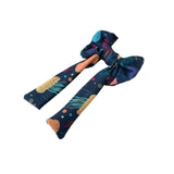 Colorful space-themed hair bow on a white background
