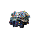 Three colorful scrunchies stacked on a white background