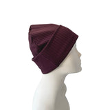 Purple knit beanie on a mannequin head against a white background