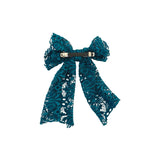 Blue lace bow hair clip on a white background