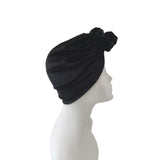 Black turban on a mannequin head against a white background