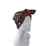 A multicolor floral-patterned headwrap turban hat displayed on a white mannequin head against a solid white background.