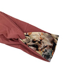 A close-up of a dusty rose sleeve with a folded cuff revealing a multicolor abstract floral pattern lining, set against a plain white background.